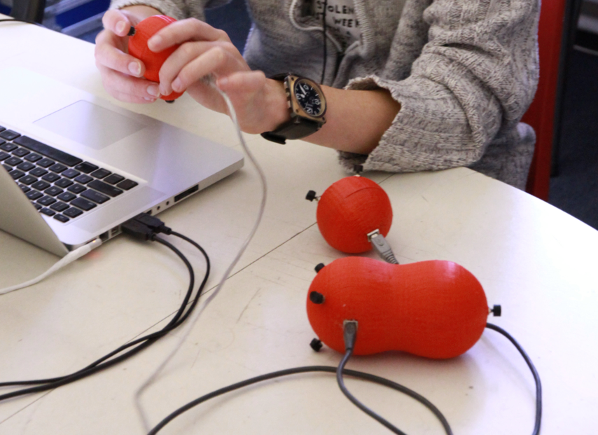 Playing a 3D-printed orange controller connected to a laptop